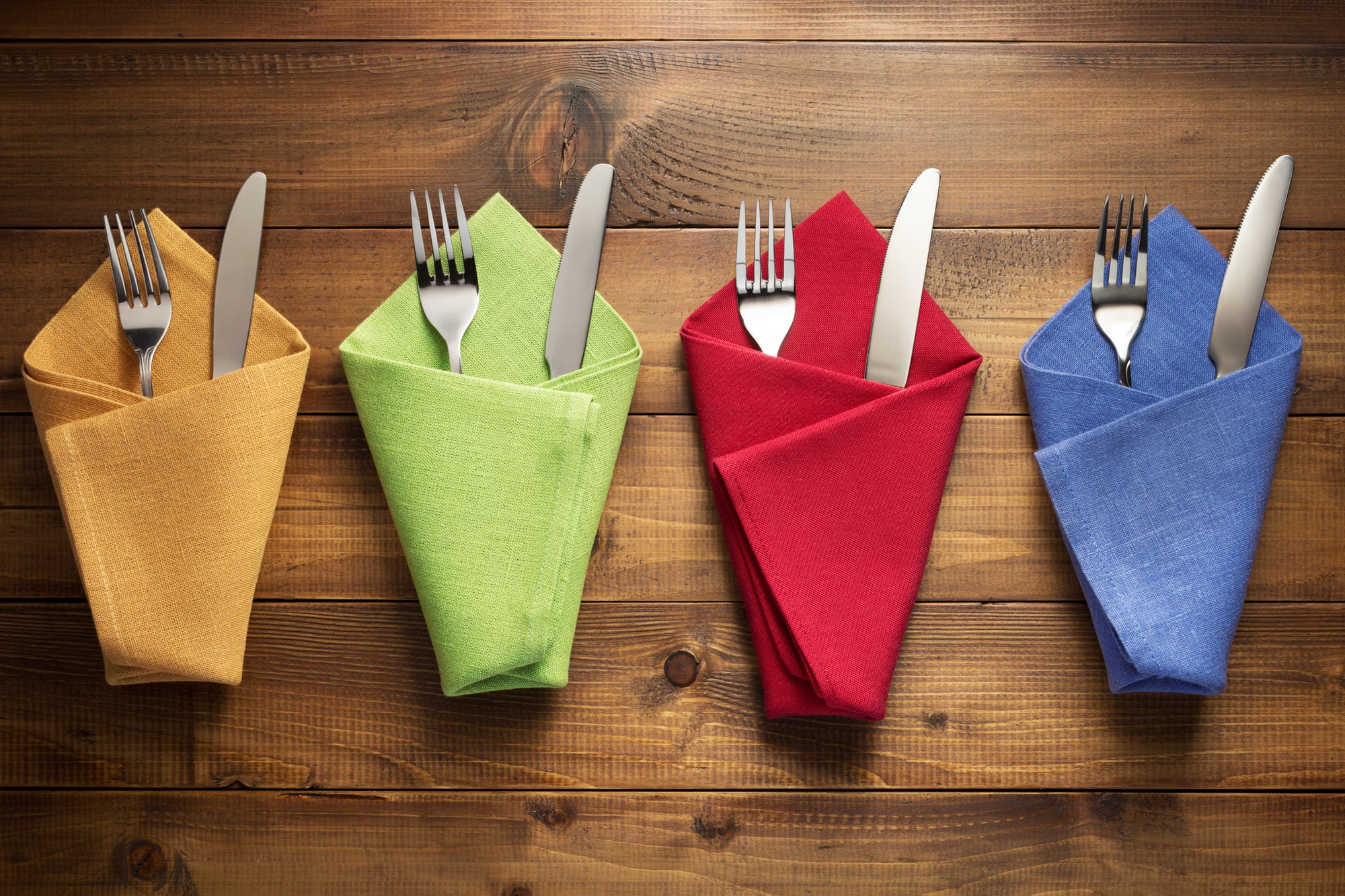 knife and fork in napkin on wood